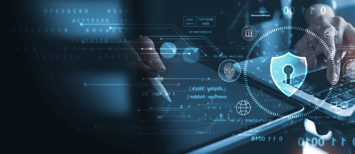 Closeup of a pair of hands. One is typing on a laptop and the other is drawing on a tablet with a stylus. There are various holograms in the foreground, most prominently a shield with a lock in the middle.