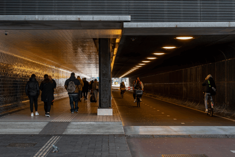 Front view of people and bicycles at an underpass tunnel in Amsterdam Netherlands November 23, 2021. Representing SmartRoute split tunneling with the PrivadoVPN app.