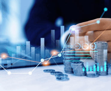 Stack of coins next to a laptop representing vpn pricing.