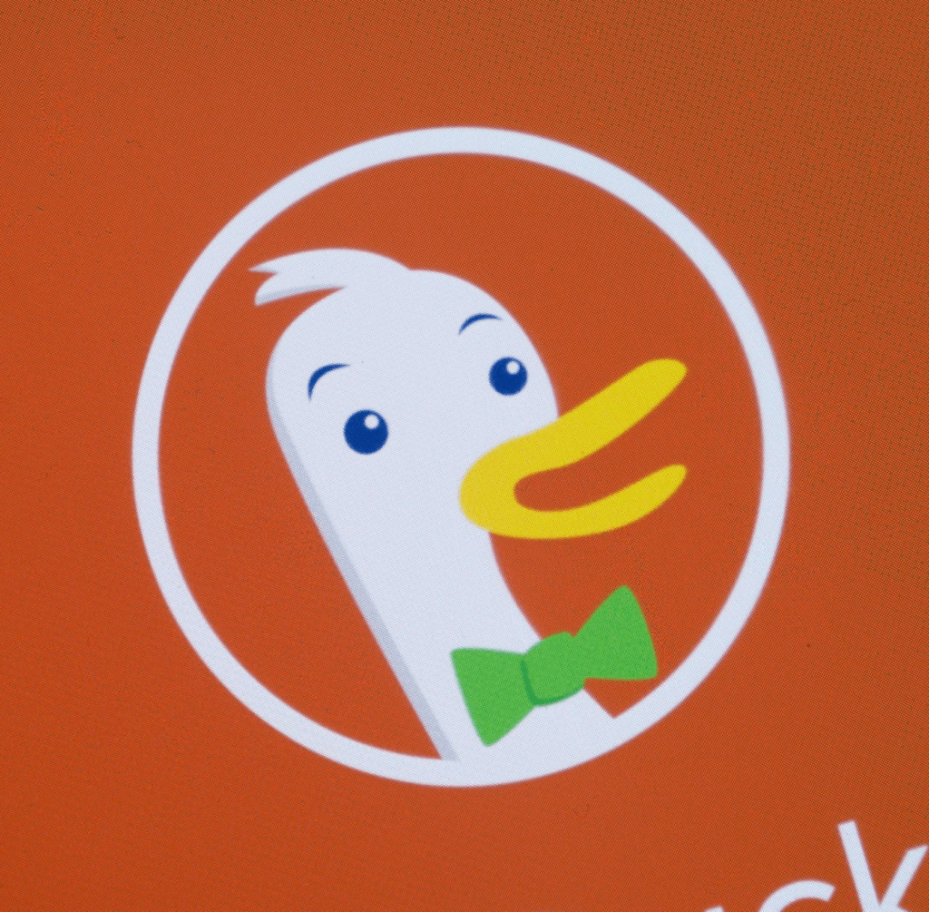Closeup of the DuckDuckGo logo, a happy duck wearing a green bowtie.