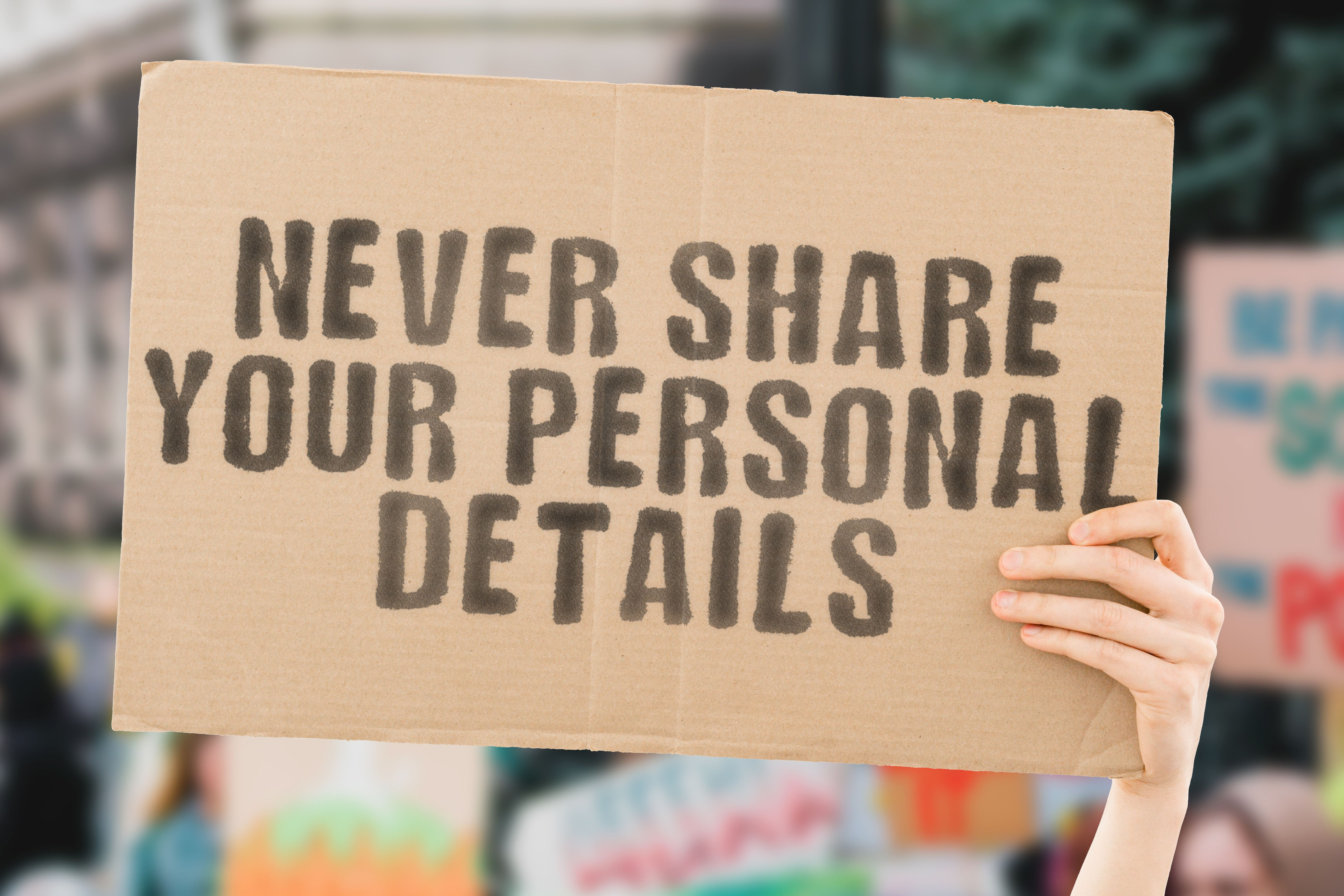 Somebody holding a cardboard sign giving the very good advice "Never Share Your Personal Details"