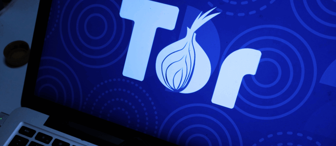 Closeup of a laptop with the full Tor logo on the screen.