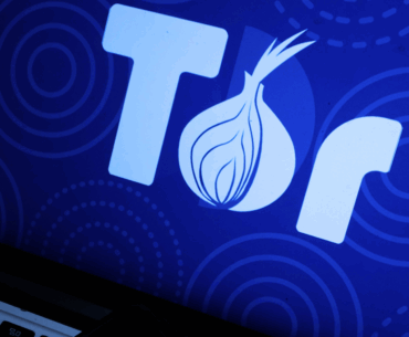 Closeup of a laptop with the full Tor logo on the screen.