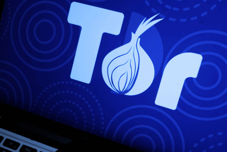 Closeup of a laptop with the full Tor logo on the screen.