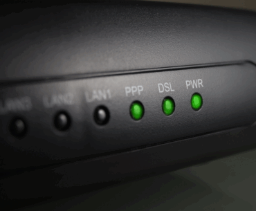 Closeup of a router with the green PPP, DSL, and PWR lights lit.
