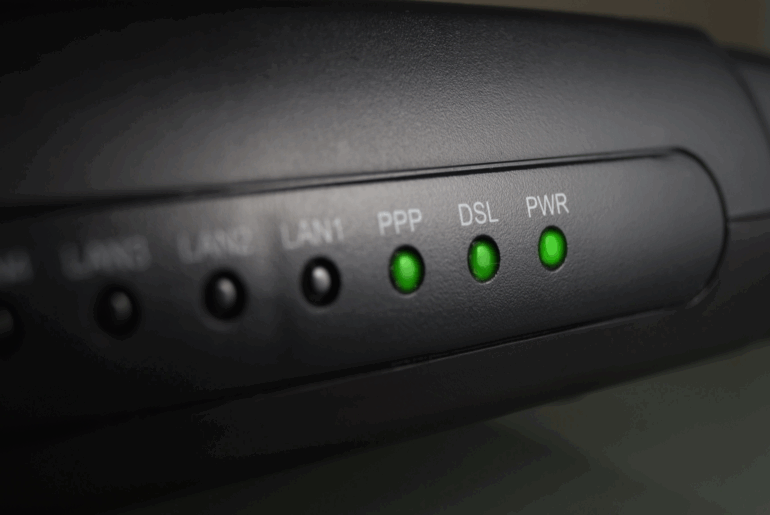 Closeup of a router with the green PPP, DSL, and PWR lights lit.
