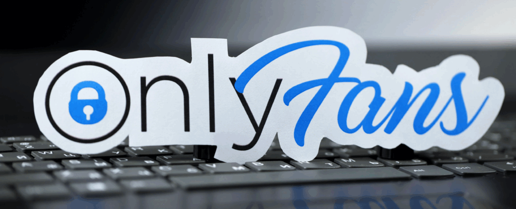 The extended OnlyFans logo as a sticker that is set up on top of a full-sized keyboard.