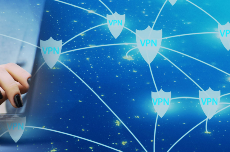 Closeup of a person's hand with black nail polish typing on a laptop. The back of the laptop fades into a star field with a bunch of shields, each emblazoned with "VPN", scattered on it. The shields are connected by lines, representing the Smart locations feature.